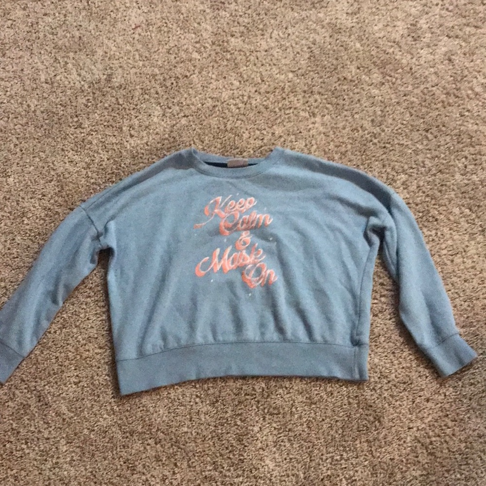 blue sweatshirt that says “keep calm and mask on” on it